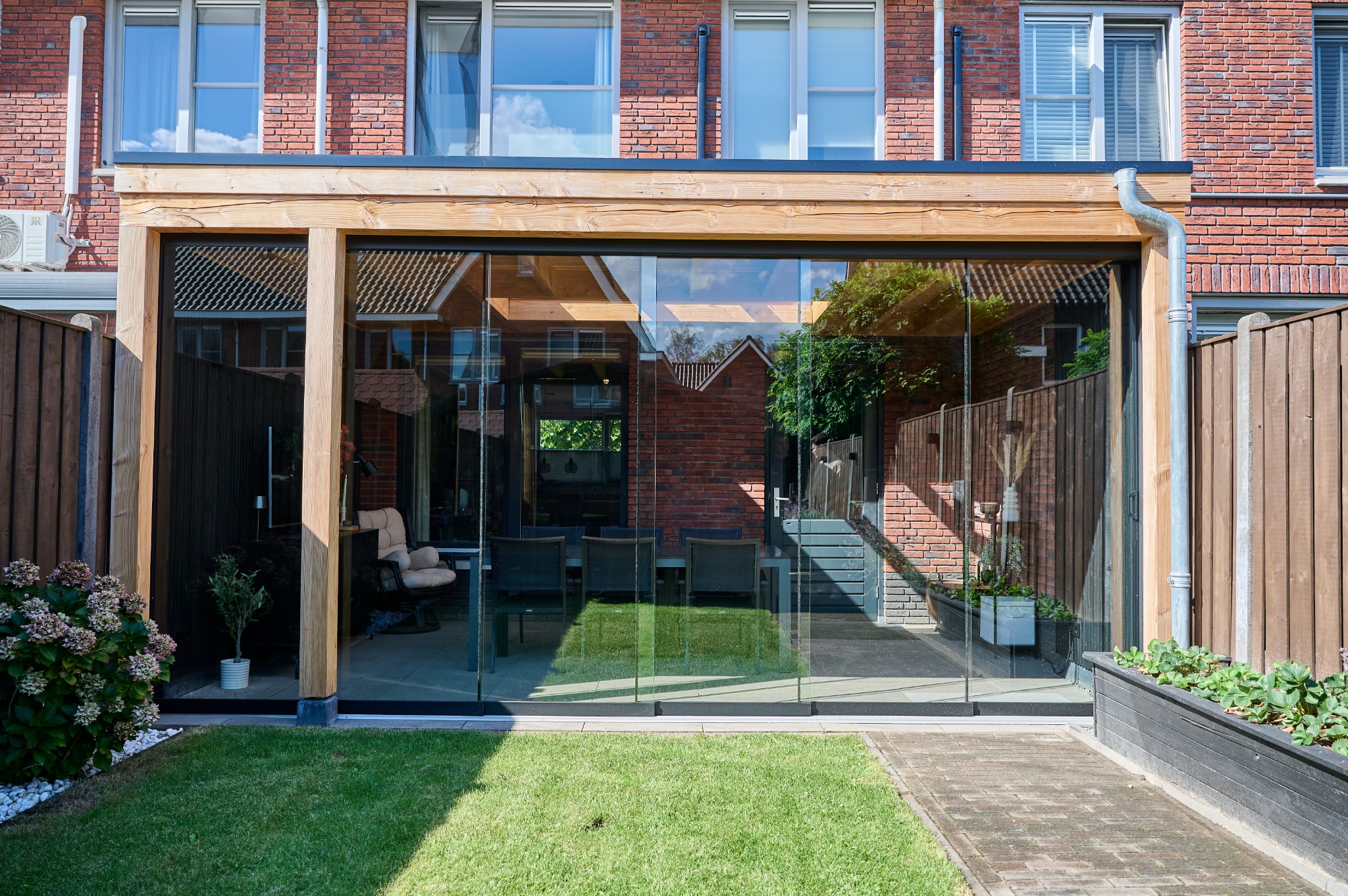 Douglashouten overkapping met glazen schuifwand en zwarte gevelbekleding in Hooge Mierde