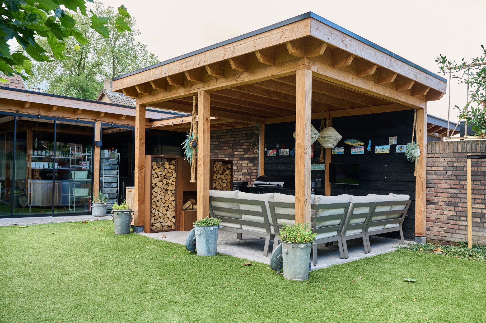 Vrijstaande douglas overkapping met loungehoek en tuinhuis in Reusel